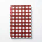 Libreta Red Picnic de costura expuesta con cadeneta de cáñamo de color visible en el lomo, vista frontal