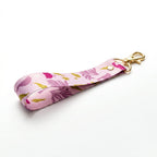 Llavero de muñeca Trino y Flora en cinta estampada de aves y flores con herraje metálico brillante, modelos A a D